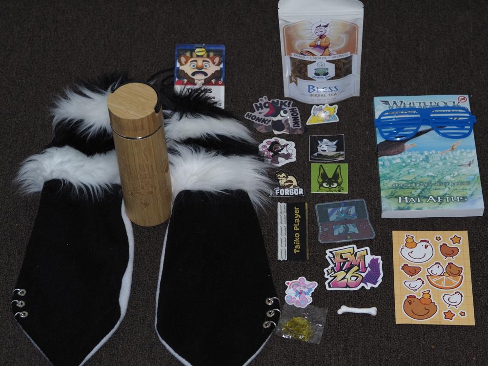 Various items on a carpet including stickers, a book, headband ears, and a bottle